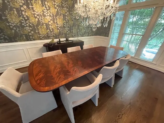 Restored mahogany dining table with inlaid banding and formal seating, showcasing expert furniture refinishing in Raleigh NC.