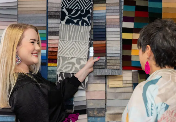 Textiles, Leathers & Vinyls 11 Finish Pros designer assisting a client during a fabric consultation, reviewing upholstery material options in the Raleigh, NC showroom.