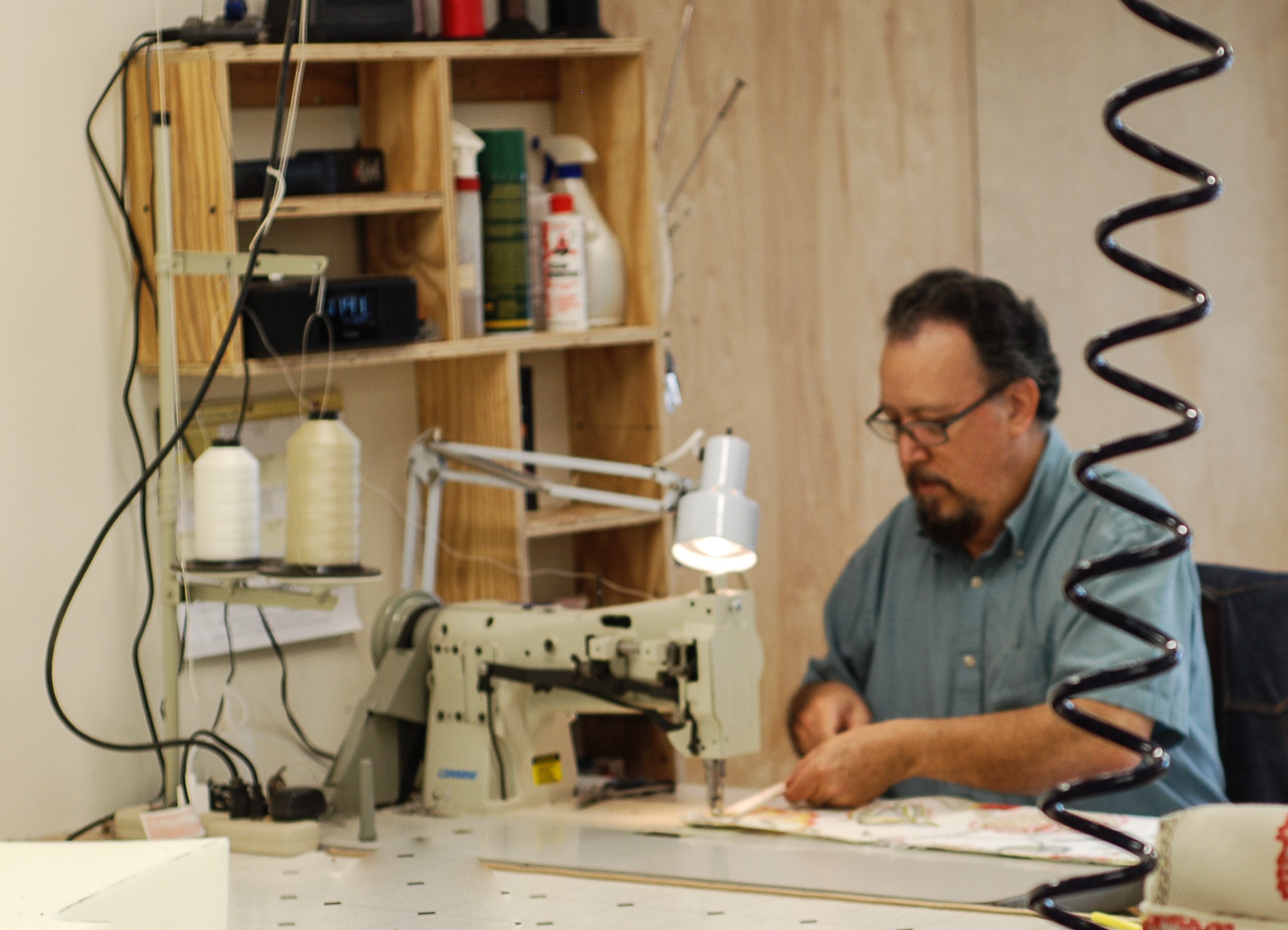 Master upholsterer at Finish Pros sewing fabric for a custom furniture reupholstery project