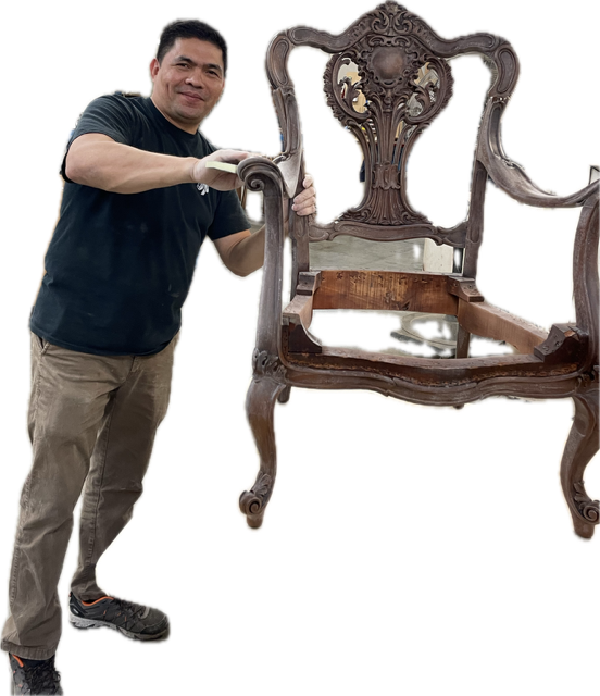 Finish Pros craftsman holding a restored antique chair frame, highlighting the furniture restoration and reupholstery expertise