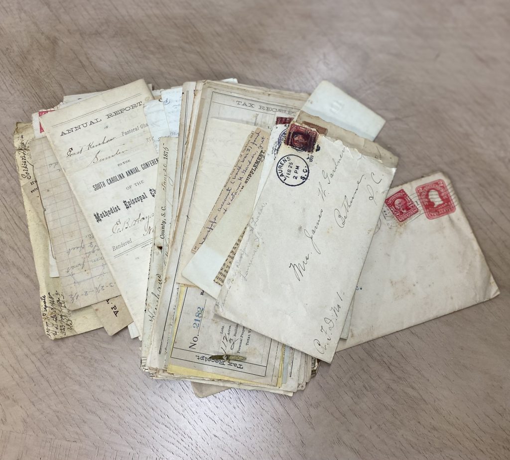 A stack of historical letters, tax receipts, and official reports dating back to the 19th century, uncovered during the restoration of a Victorian mahogany desk.