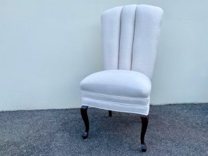 A fully restored chair with a modern, linen-look fabric and polished mahogany legs, blending antique design with contemporary elegance.