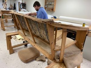 Repadding stage of a 1920s sofa restoration, with fresh cushioning materials being added for enhanced comfort.