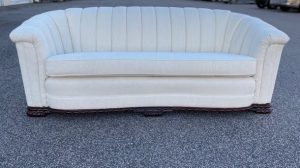 Restored 1920s art deco channel-back sofa upholstered in ivory boucle fabric, showcasing a timeless and elegant design.