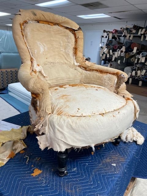 Antique chair stripped down to horsehair stuffing, showing traditional upholstery techniques used at Finish Pros