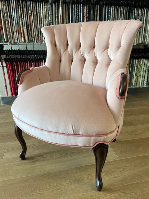 Restored antique tufted chair in blush pink velvet with contrast piping and dark wood legs