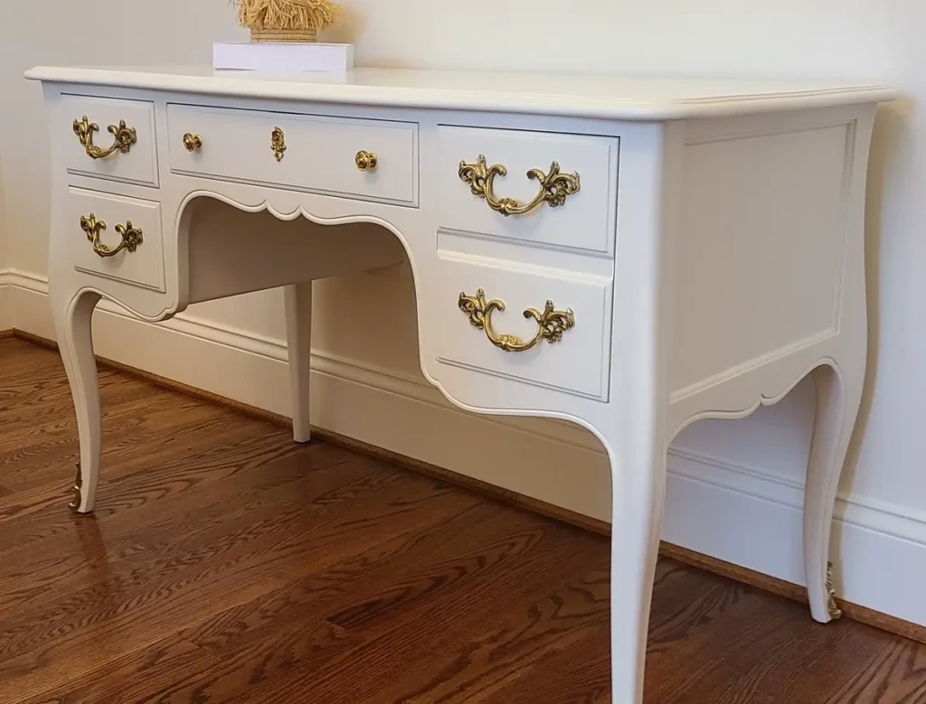 French Provincial desk refinished in smooth white painted lacquer with original brass hardware, completed by Finish Pros in Raleigh NC.