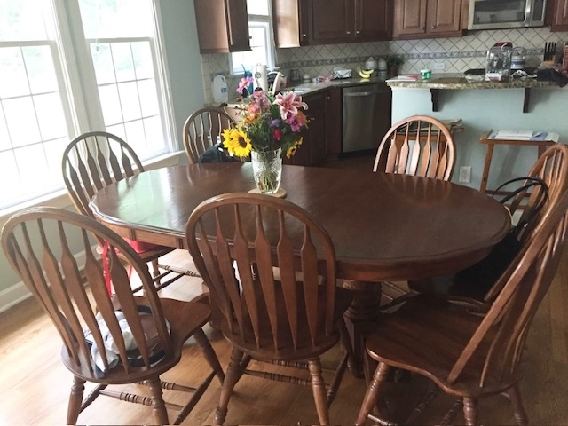Solid oak dining table in original brown finish before painted lacquer refinishing project in Raleigh NC.