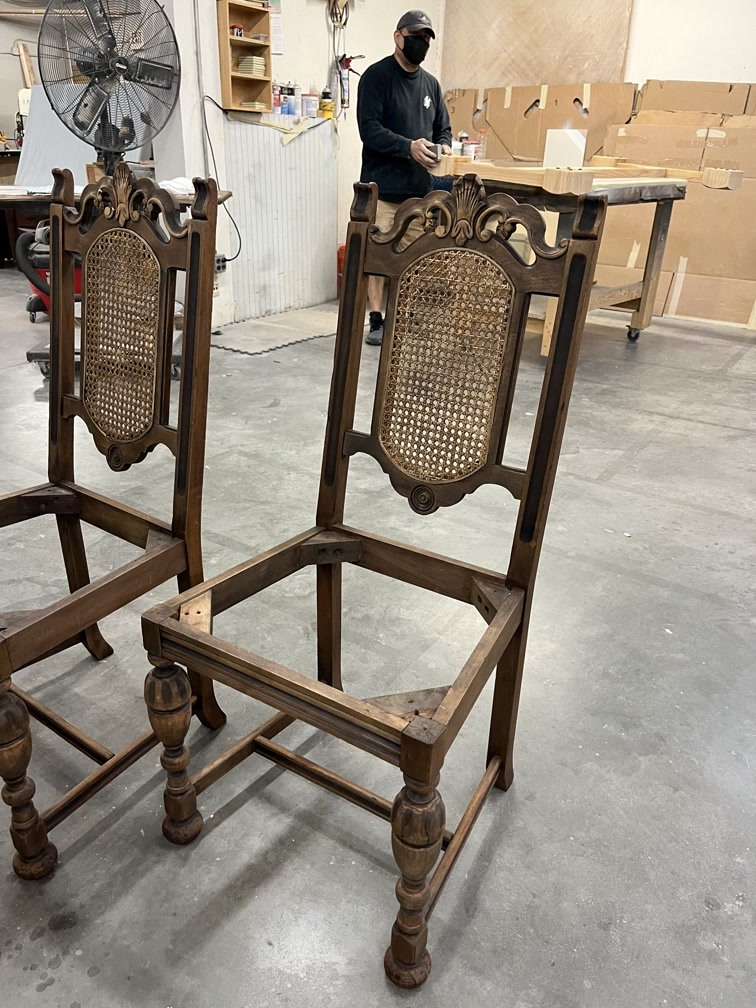 Eileen’s antique dining chairs mid-process at Finish Pros, awaiting joint re-gluing and structural reinforcement as part of a full restoration.