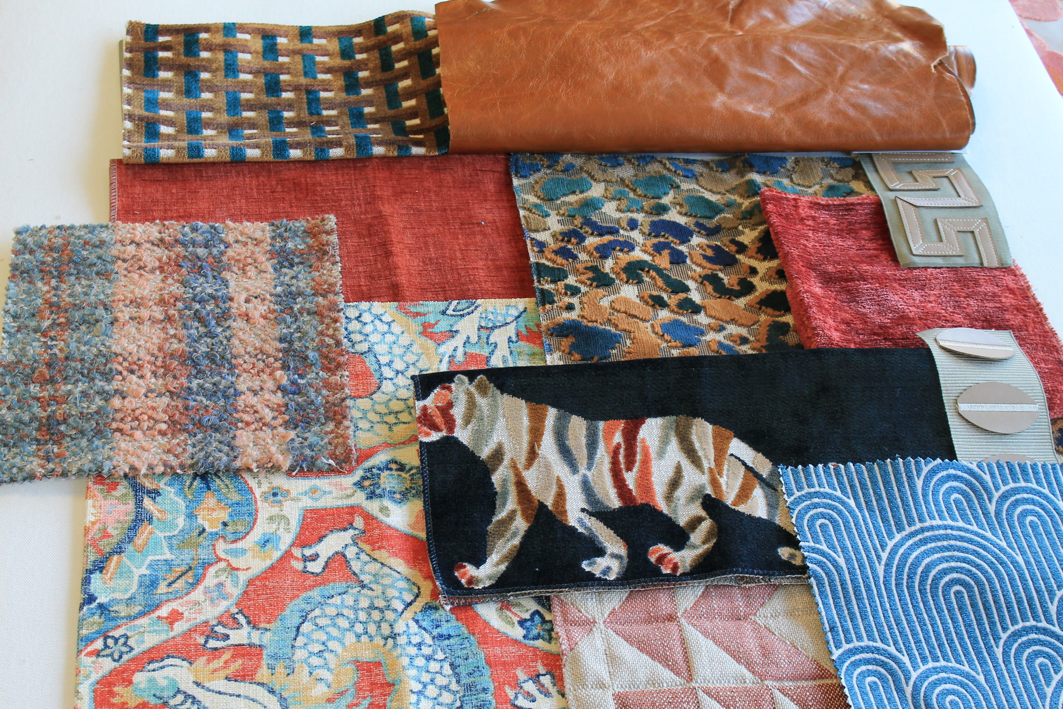 Collage of bold, colorful fabric swatches from various brands we carry, featuring animal prints, textured wovens, leather, and vibrant patterns.