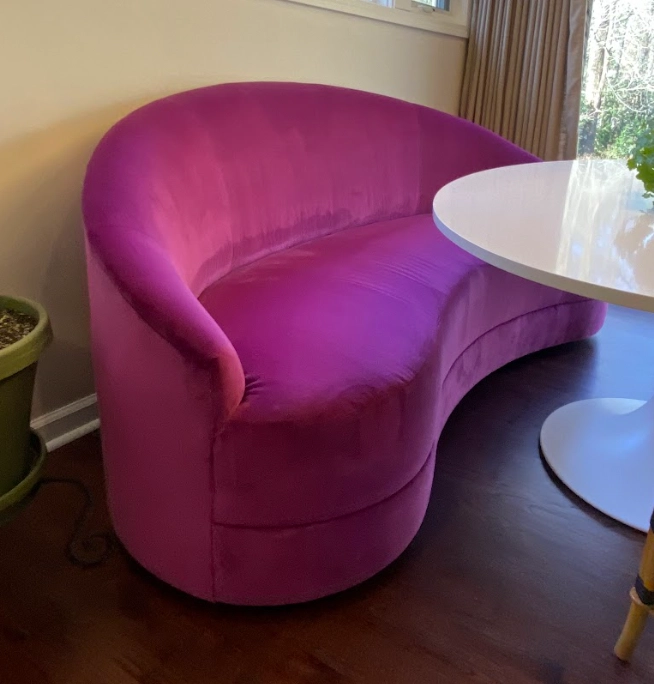 Magenta velvet curved sofa reupholstered by Finish Pros in Durham NC, highlighting modern custom upholstery work with luxe fabric and seamless contour craftsmanship. Protecting Upholstery Fabric