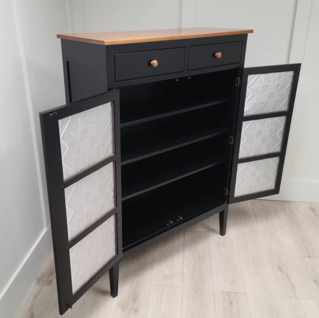 Custom black pie safe with natural wood stained top and hardware, featuring decorative tin panel inlays on the doors, refinished by Finish Pros with matte black lacquer.