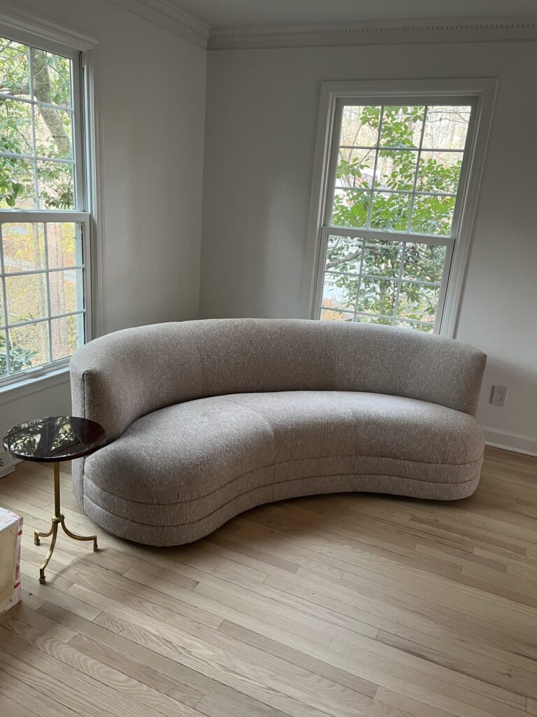 The Art of Reupholstery: How Finish Pros Transforms Raleigh Furniture with Craftsmanship and Care 3 Curved contemporary sofa fully reupholstered by Finish Pros in a soft, neutral fabric.