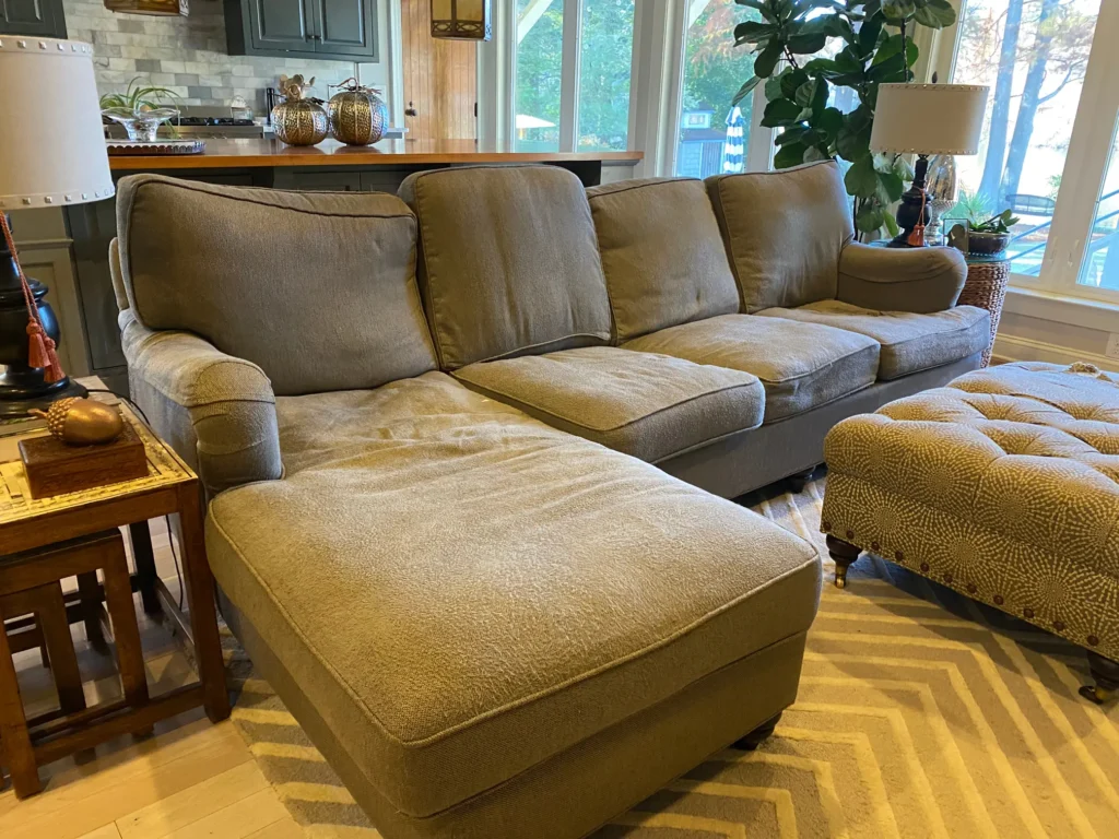 Sagging sectional sofa in need of cushion foam replacement, photographed in a Raleigh NC home, showing flattened seat and poor support before professional restoration by Finish Pros.
