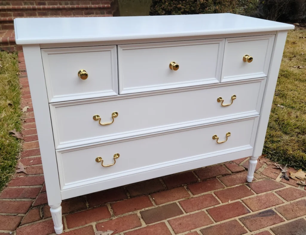 Will I ruin my furniture by painting? 4 Vintage dresser refinished in a smooth white lacquer with polished gold hardware, photographed outdoors after restoration by Finish Pros.