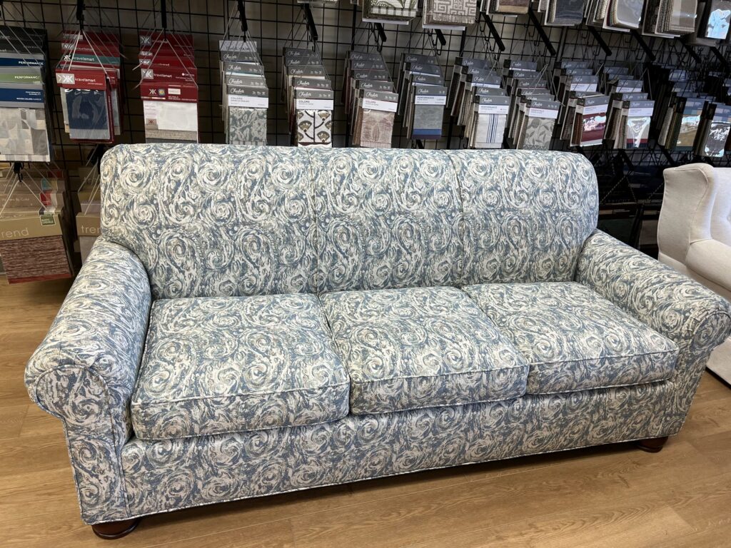 2026 Furniture Color Trends: How to Refresh Your Home with Expert Refinishing & Upholstery 5 This sofa showcases a fresh take on the classic neutral, reimagined in Barrow’s Birmingham 11914, a soft mist blue performance fabric with subtle pattern and texture. The lighter tone brings a sense of openness and elegance, aligning perfectly with 2026’s trend toward calm, livable upholstery.