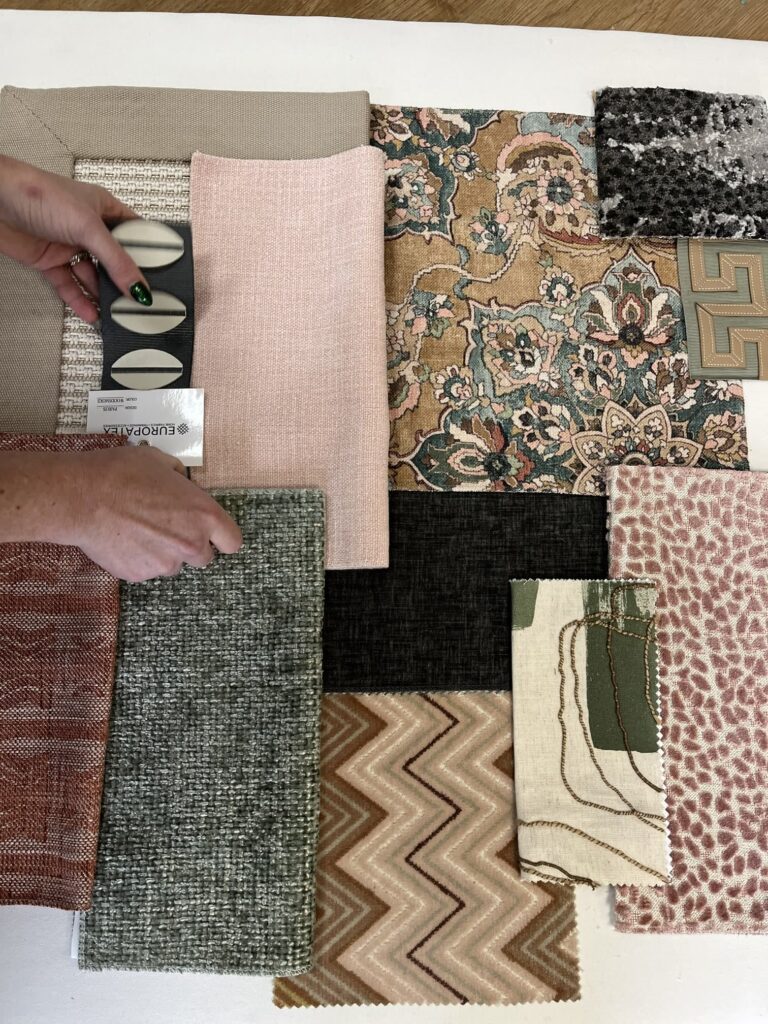 What Happens During a Finish Pros Design Consultation? 2 Designer selecting upholstery fabric samples in various textures and patterns at Finish Pros in Raleigh NC for custom furniture reupholstery