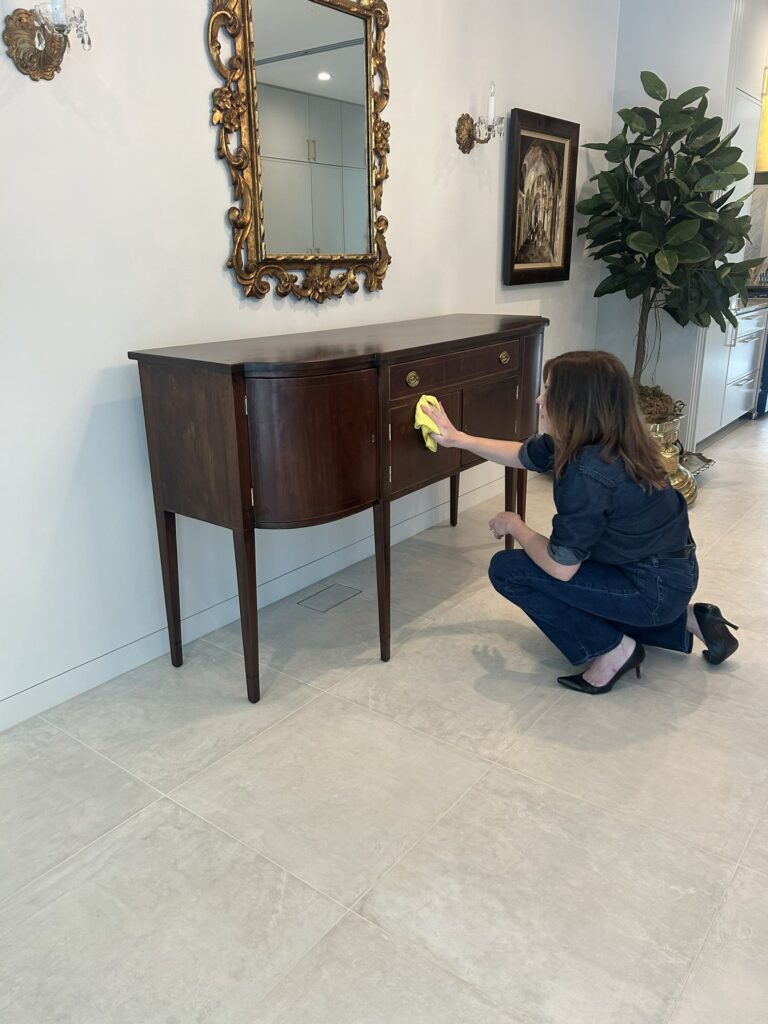 What Happens During a Finish Pros Design Consultation? 6 Colleen from Finish Pros in Raleigh NC polishing a refinished sideboard during delivery and client follow-up after furniture refinishing