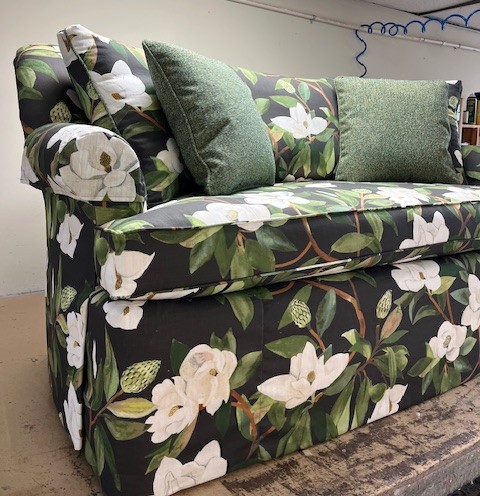 What Reupholstery Costs in Raleigh, and the 7 Things That Move the Price 4 Curved-back sofa reupholstered in large-scale magnolia print with waterfall dressmaker skirt, Finish Pros Raleigh NC