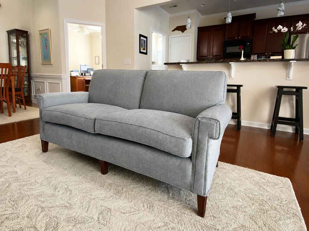 What Reupholstery Costs in Raleigh, and the 7 Things That Move the Price 1 reupholstery costs raleigh Sofa reupholstered in blue-gray herringbone chevron with exposed tapered legs by Finish Pros, Raleigh NC